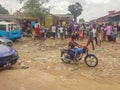 View of slum with a exterior market in the Luanda city downtown center with clay road, people, vehicles and buildings