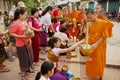 Monks collect alms and offerings during daily early morning procession in Luang Prabang, Laos.