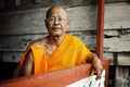 smoking head buddhist monk resting at his monastery during the afternoon heat with glasses