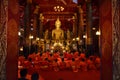 LUANG PRABANG, LAOS - MARCH 20 2018: Group of monks pray in Wat May Suwannaphumaham Temple in Laos