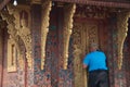 Asian male tourists stand and looking through the door hole of Marn chapel in Wat Xieng Thong.