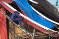 Asian male workers painting the roof of the main church at Wat Xieng Thong. Royalty Free Stock Photo