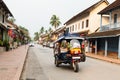 Luang Prabang, Laos - May 2019: tuk-tuk motorcycle taxi riding on the city main street