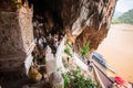 A group of tourists stunning view and taking photo at Pak Ou Caves, famous caves in the limestone cliff are crammed myriad buddha