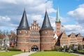 Lubeck, Germany, April 11, 2022: Holstentor or Holsten gate, famous medieval landmark in red brick architecture, entrance to the