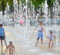 Children playing in beautiful modern fountain in park, Lublin