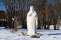 Lublin, Poland. 08 February 2023. White figure of Virgin Mary in snow outside old church in winter