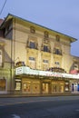 The Lucas Theatre For the Arts with a marquee in lights in a white building with green trim with blue sky at sunset in Savannah