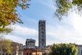 Downtown Lucca in Tuscany framed by autumn foliage with a view of the San Frediano Basilica