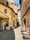 Old narrow medieval street with bar and shops in the historic center of old town Lucca, Tuscany, Italy Royalty Free Stock Photo