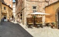 Old narrow medieval street with bar and shops in the historic center of old town Lucca, Tuscany, Italy Royalty Free Stock Photo