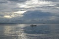 Fishermen on tiny fishing boat on the sea before sunrise Royalty Free Stock Photo