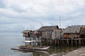 Small fishing boat anchored beside the over water stilt Bajau shanty houses. Long shot