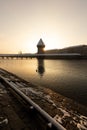 Lucerne, Switzerland, February 4, 2019: Lucerne with snow covered wooden bridge called chapel bridge and water tower with river