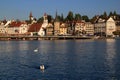 Lake Lucerne waterfront with historic buildings and swans in the foreground in the city of Lucerne, Switzerland