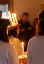 Lucia parade with singing girls and boys in white dresses holding candles. Traditional celebration of the suffering of saint