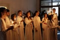 Lucia parade with singing girls and boys in white dresses holding candles. Traditional celebration of the suffering of saint