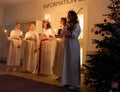 Lucia parade with singing girls and boys in white dresses holding candles. Traditional celebration of the suffering of saint Lucia