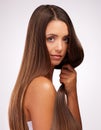 Lucious locks. Studio portrait of an attractive young woman posing against a grey background.