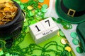 The luck of the Irish meme and Happy St Patricks day concept theme with a calendar, leprechaun hat, beads necklace and pot of gold