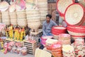 A tribal man is selling a variety of traditional wooden toys and bamboo baskets.