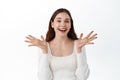 Lucky beautiful girl rejoicing from good news, laughing and smiling, raising hands up to celebrate joyful positive Royalty Free Stock Photo