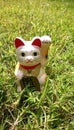 lucky cat, japanese doll ingot mean symbol good luck charm. closeup vertical white figurine known as Maneki Neko. Royalty Free Stock Photo