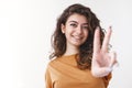Lucky emotive charismatic optimistic young curly-haired girl black hair extending arm showing you peace victory gesture