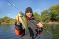 Man holding bass. Fishing scene, catch of fish