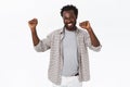 Lucky happy handsome african american bearded guy do champion dance, raising hands up, smiling cheerfully and triumphing