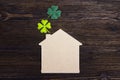 Lucky home symbol with four-leaf clover on wooden background. Co Royalty Free Stock Photo