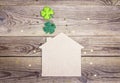 Lucky home symbol with four-leaf clover on wooden background. Co Royalty Free Stock Photo