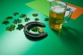 Lucky horseshoe with shamrocks and beer mug on green background and flag of ireland for st patrick day Royalty Free Stock Photo