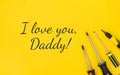 Lucky inscription I love you, Daddy with work tools on a yellow background. Congratulations and gifts. View from above. Father`s