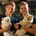 Lucky to be together. Twins men hold pedigree dogs. Happy twins with muscular look. Muscular men with dog pets. Spitz