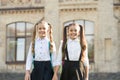 Lucky to meet each other. Cheerful smart schoolgirls. Happy schoolgirls outdoors. Small schoolgirls wear school uniform