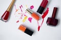 Lucky on a white background, with smears of varnish. Orange, burgundy, red.Choosing varnishes for manicures in a beauty