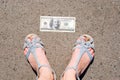 Lucky woman finding money on the street. Women feet next to hundred dollar bill. Lost and found money lying down on