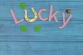 Lucky word and horseshoe on blue wooden board 3D illustration.