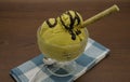 Lucuma ice-cream with chocolate syrup and roll wafer.