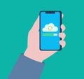 A hand holding a phone. Files are being uploaded to the cloud on the phone screen. Royalty Free Stock Photo