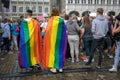 LUEBECK, GERMANY, AUGUST 17, 2019: two young people from behind are wearing rainbow flags as capes, colorful eye-catcher in the