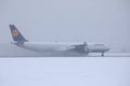 Lufthansa plane doing taxi on runway, snow in winter