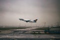 Lufthansa plane taking off from the Frankfurt airport under a gloomy sky on a rainy day in Germany