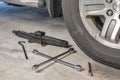Lug wrench and car jack in a garage