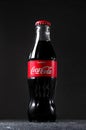 Lugansk, Ukraine - July 25, 2021: Coca Cola in glass bottle on dark background. Creative minimal concept