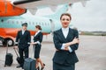 With luggage. Aircraft crew in work uniform is together outdoors near plane Royalty Free Stock Photo