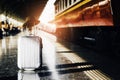 Luggage and hat are placed on platform in the train station, wh