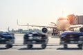 Luggage motion blurred trolley cart going fast delivering passenger baggage to modern plane on taxiway at airport on