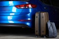 Luggage stand next to closed car trunk